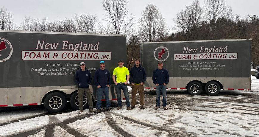 New England Foam and Coating employees are standing in front of two trailers.
