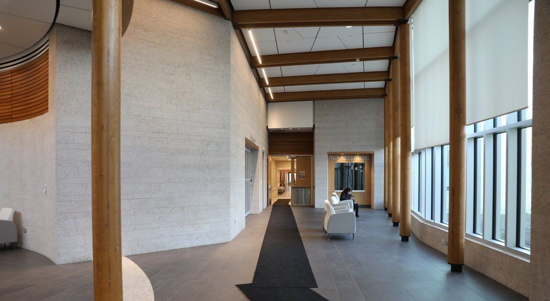 A long hallway in a building with a lot of windows rendering for NHCN Nanatawiwekamik Health Centre