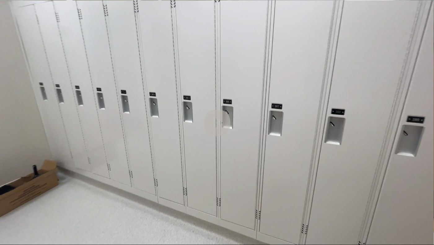 A row of white lockers in a locker room.