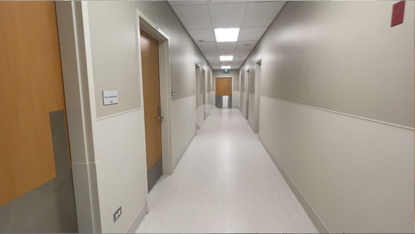 A long hallway in a hospital with a lot of doors.