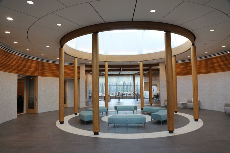 A large room with a circular ceiling and wooden pillars