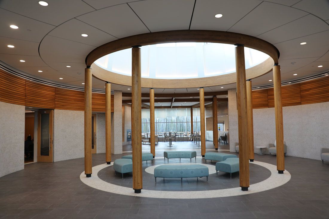 A large room with a circular ceiling and wooden pillars