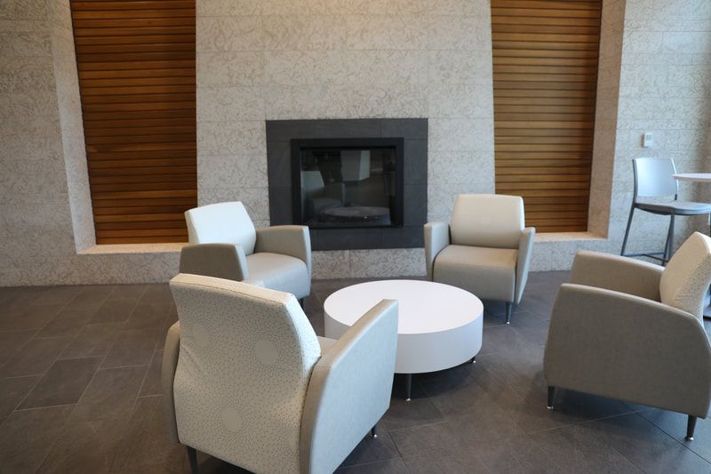 A living room with chairs and a fireplace
