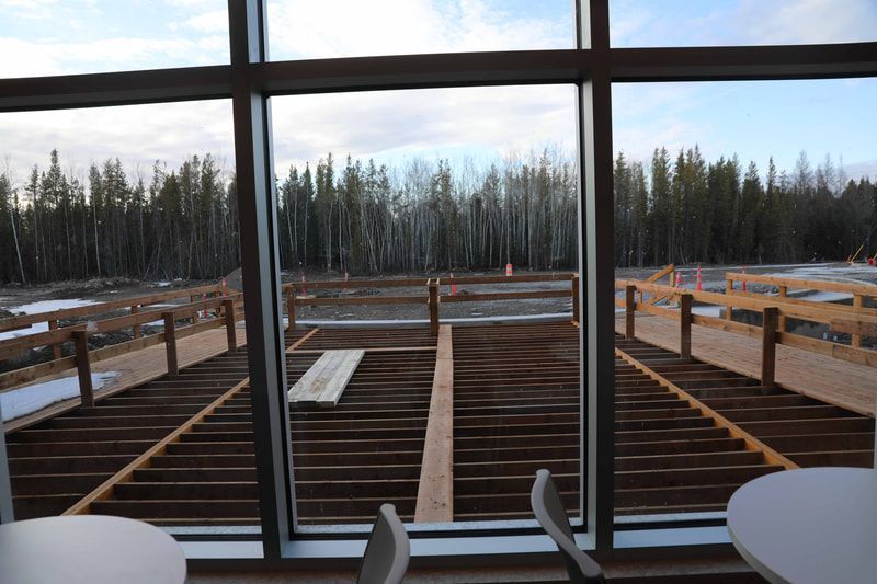 A view of a wooden deck through a large window.