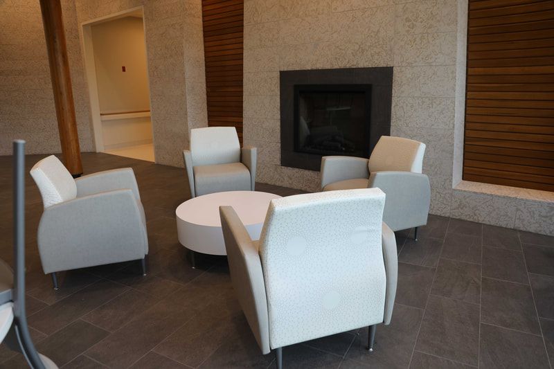 A living room with chairs , a table and a fireplace.