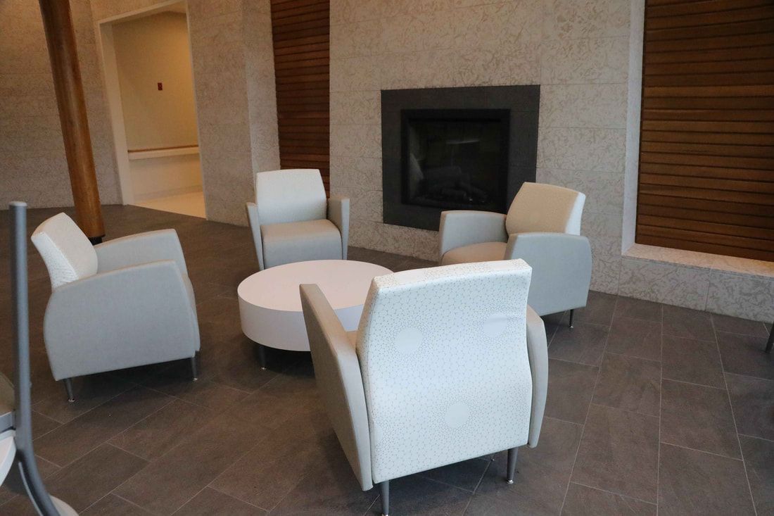 A living room with chairs , a table and a fireplace.