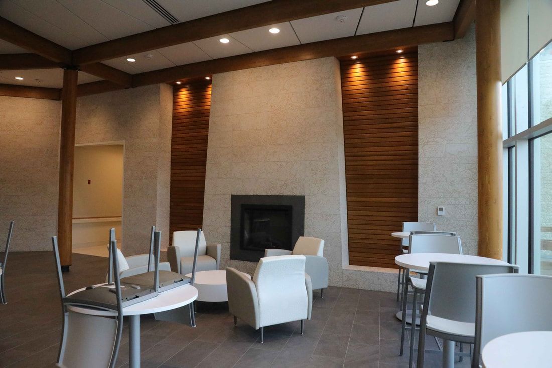 A living room with tables and chairs and a fireplace