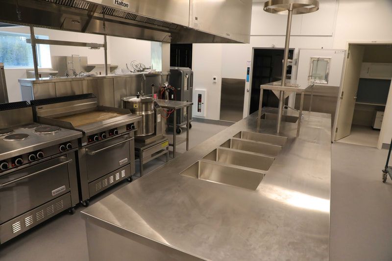 A kitchen with a lot of stainless steel appliances and a sink.