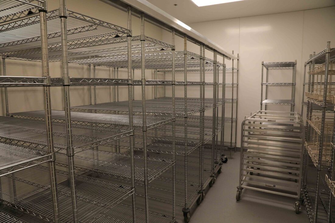 A room with a lot of shelves and carts in it.