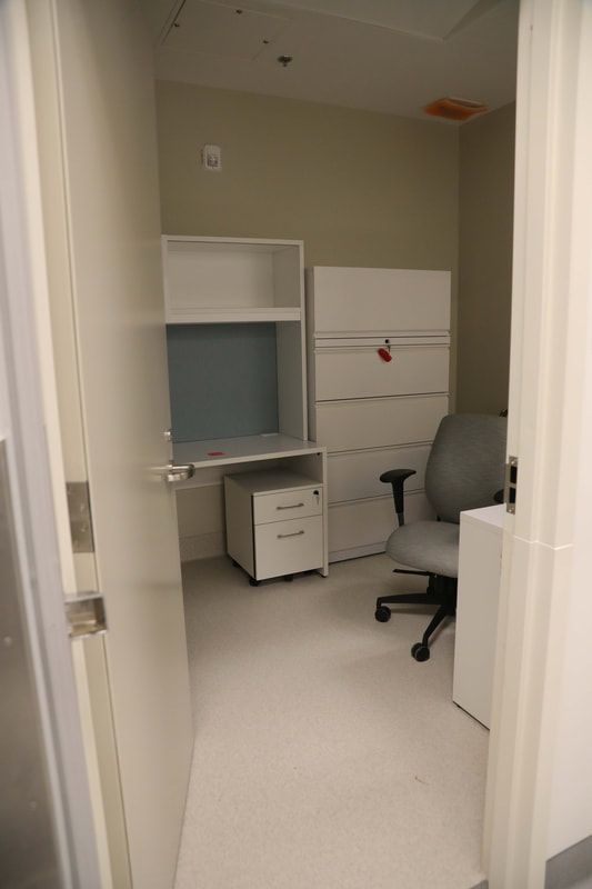 A small room with a desk and chair in it