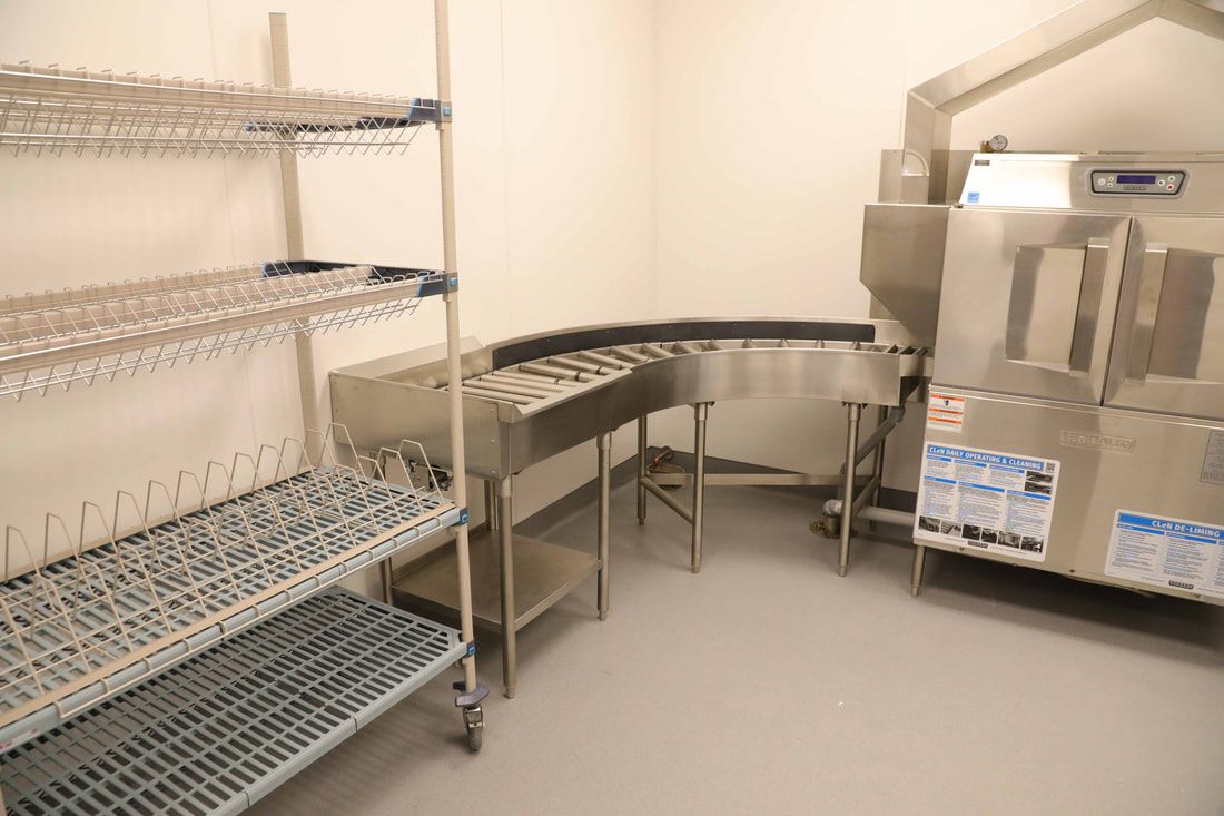 A kitchen with stainless steel shelves and a dishwasher
