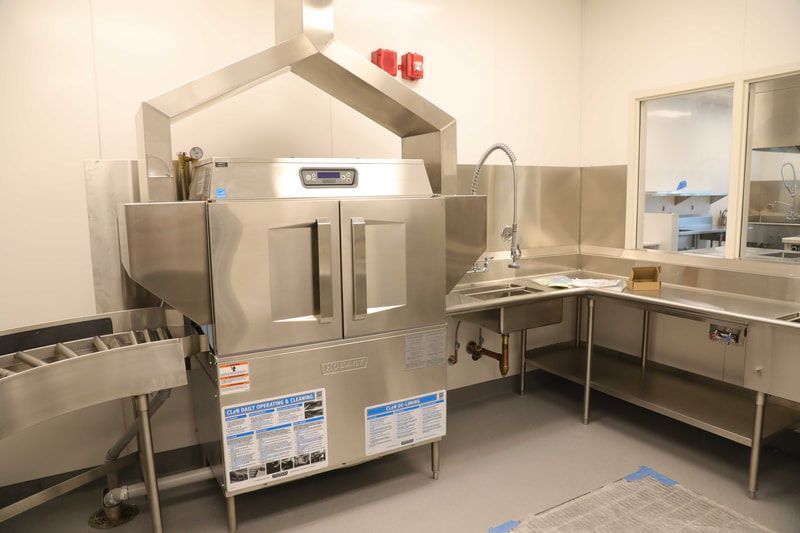 A stainless steel dishwasher is sitting in a kitchen next to a sink.