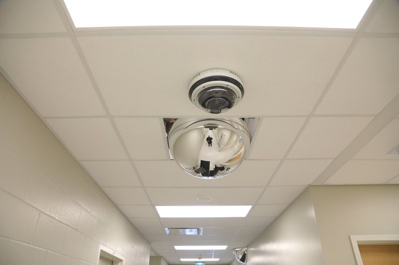 A hallway with a smoke detector on the ceiling.