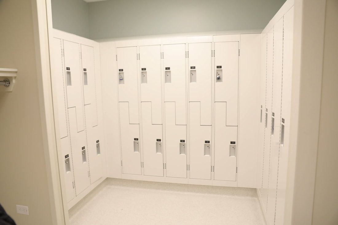 A locker room filled with lots of white lockers