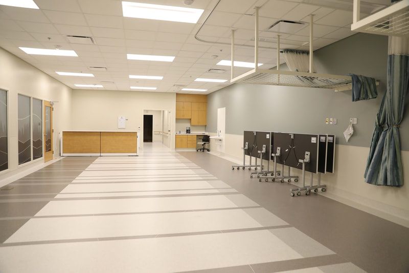 A large empty room with tables and chairs in it.