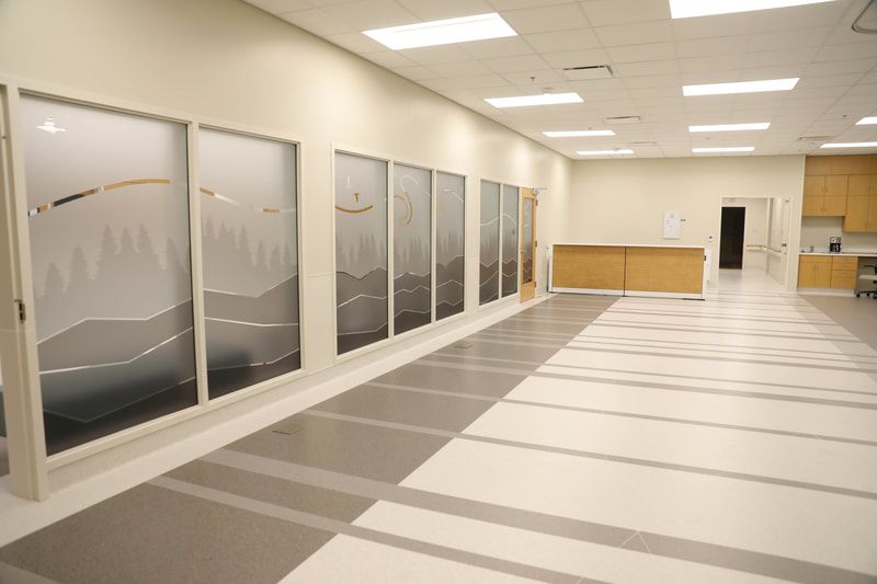 A long hallway with a lot of windows and a striped floor.