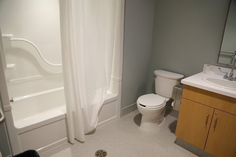 A bathroom with a toilet , sink and bathtub.