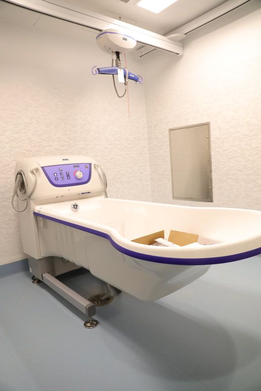 A white and purple bathtub in a hospital room