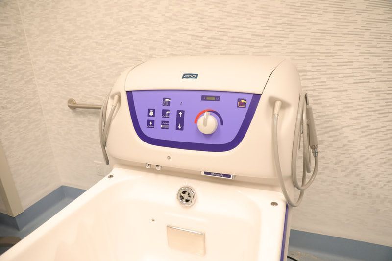 A white and purple bathtub with a purple control panel.