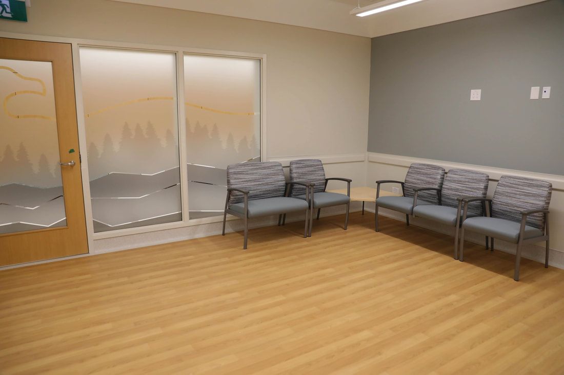 A waiting room with a lot of chairs and a door.