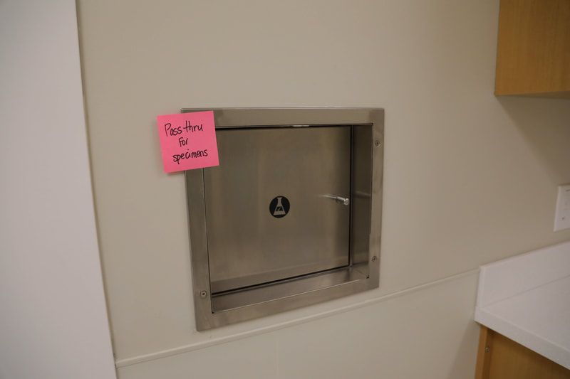 A stainless steel door with a pink sticky note on it that says pay here to grace