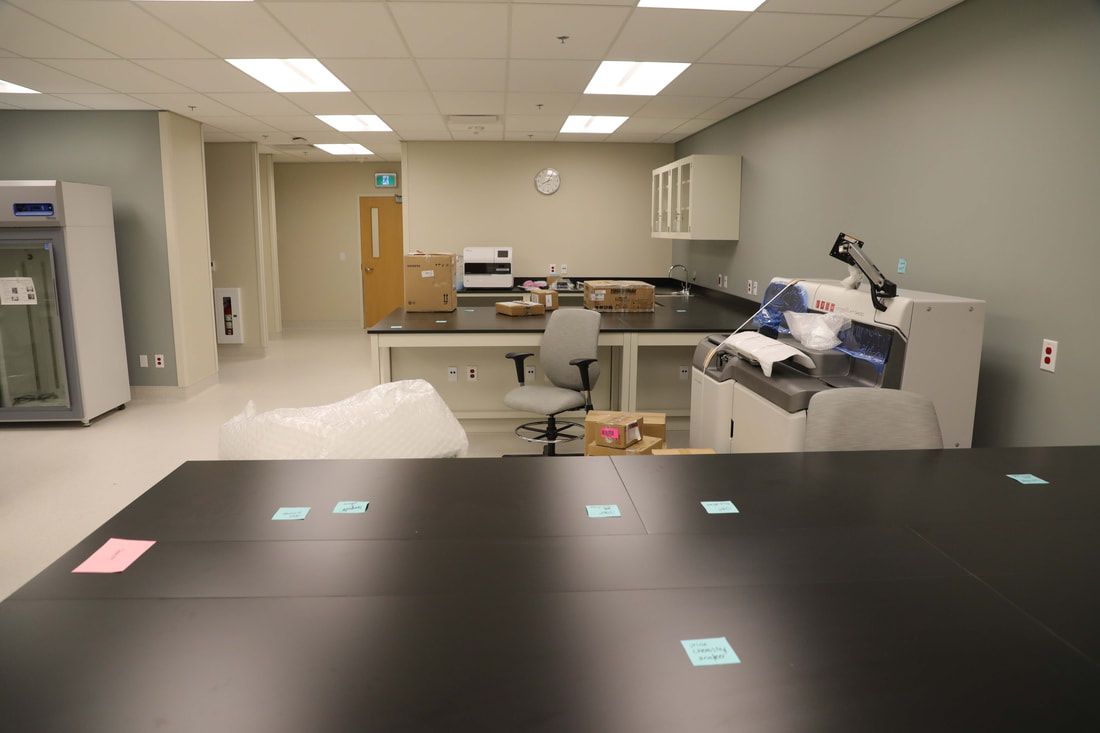 A laboratory with a table and chairs and a printer.