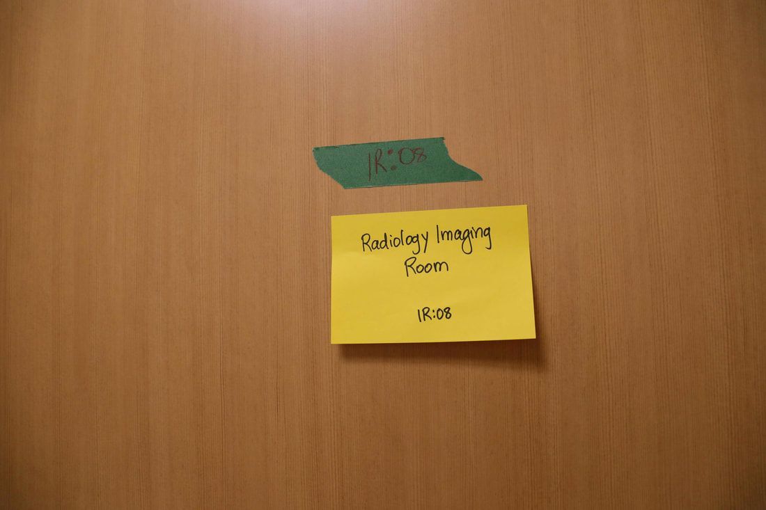 A yellow sticky note on a wooden door that says prayer room