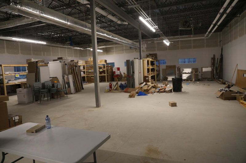 A large empty warehouse with a table in the middle of it.