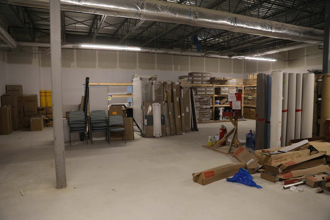 A large warehouse filled with lots of boxes and chairs.
