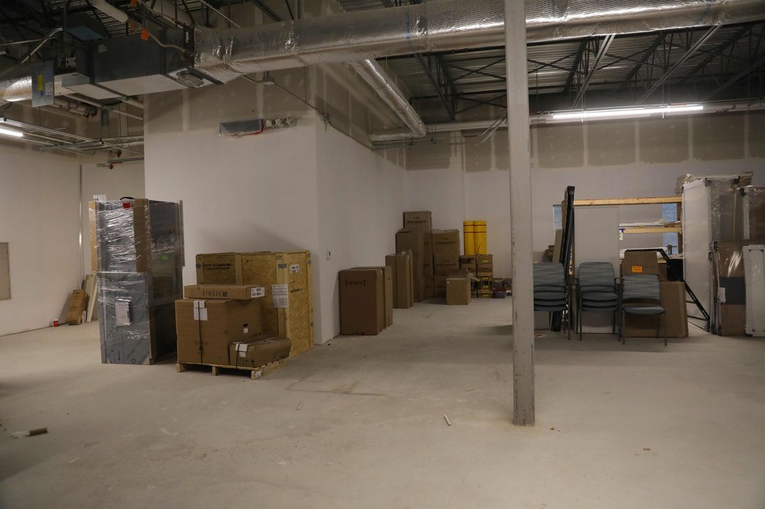 A large empty room with a lot of boxes on the floor.
