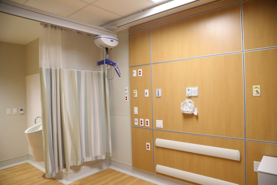 A hospital room with a shower curtain and a sink.