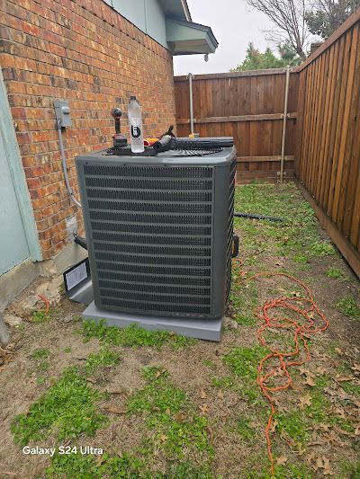 A large air conditioner is sitting in the backyard of a house.