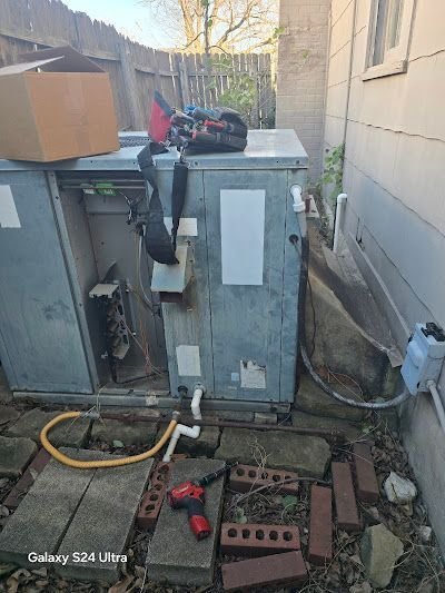 A couple of air conditioners are sitting outside of a house.