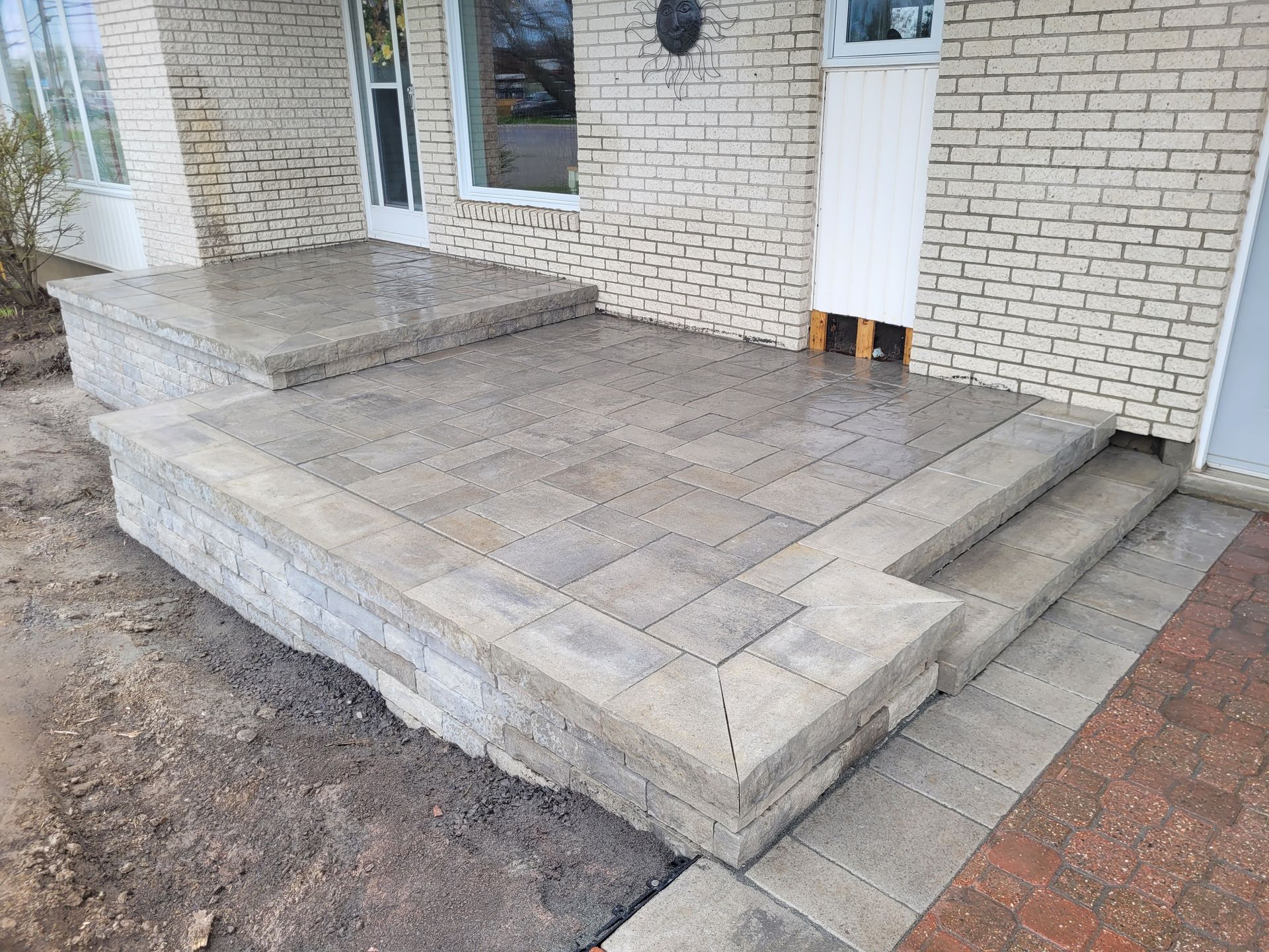 Brick patio with steps and retaining wall.