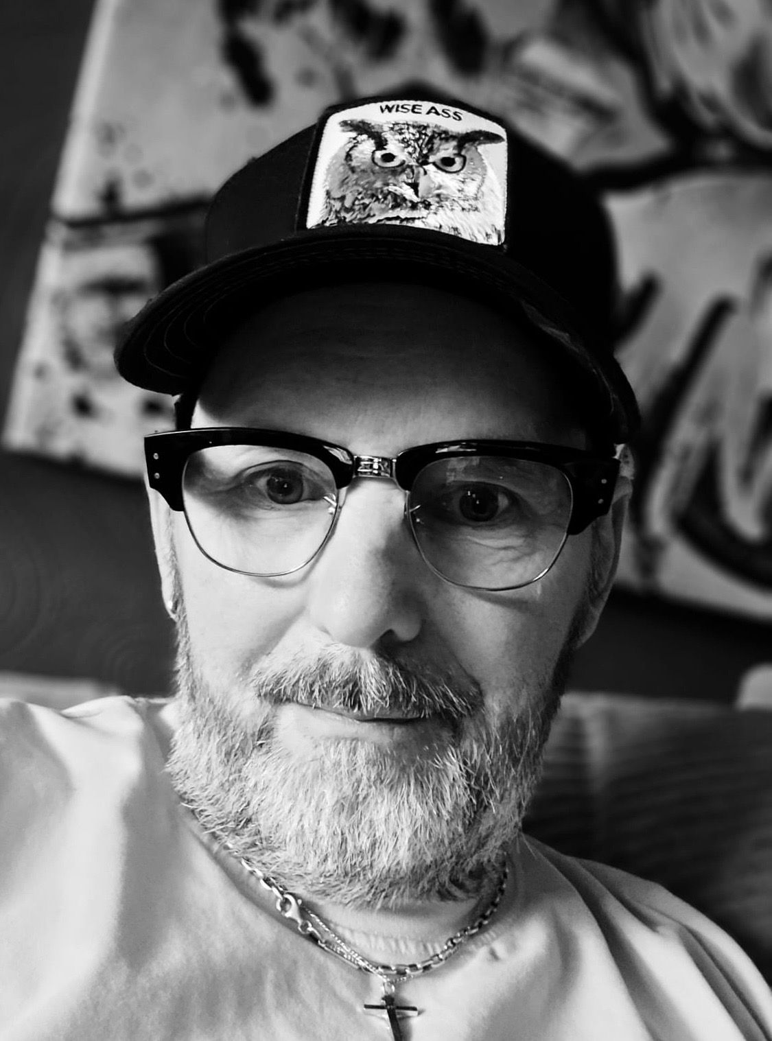Ein Mann mit Bart trägt eine Brille und einen Hut.