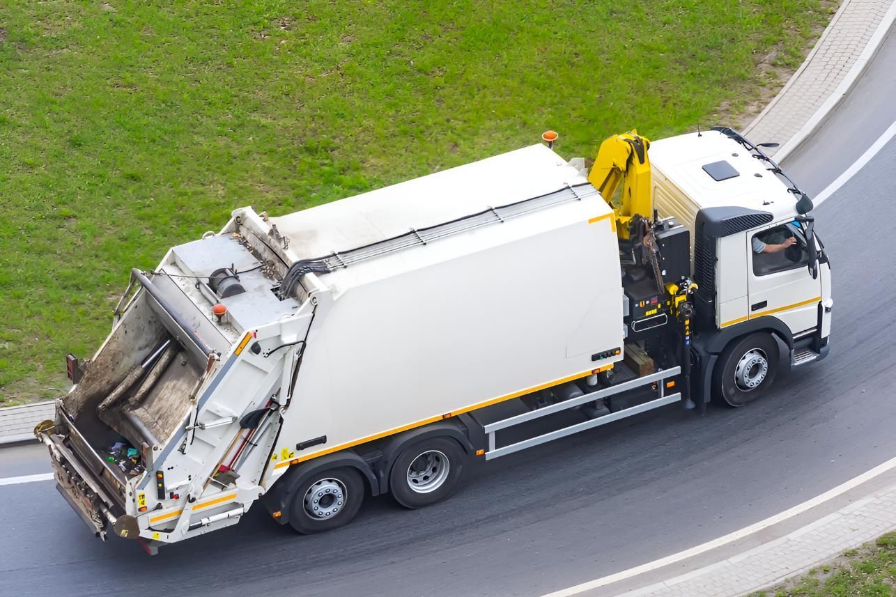 An Aerial View Of A Garbage Truck Driving Down A Road — Porta-Vac in Bowen, QLD