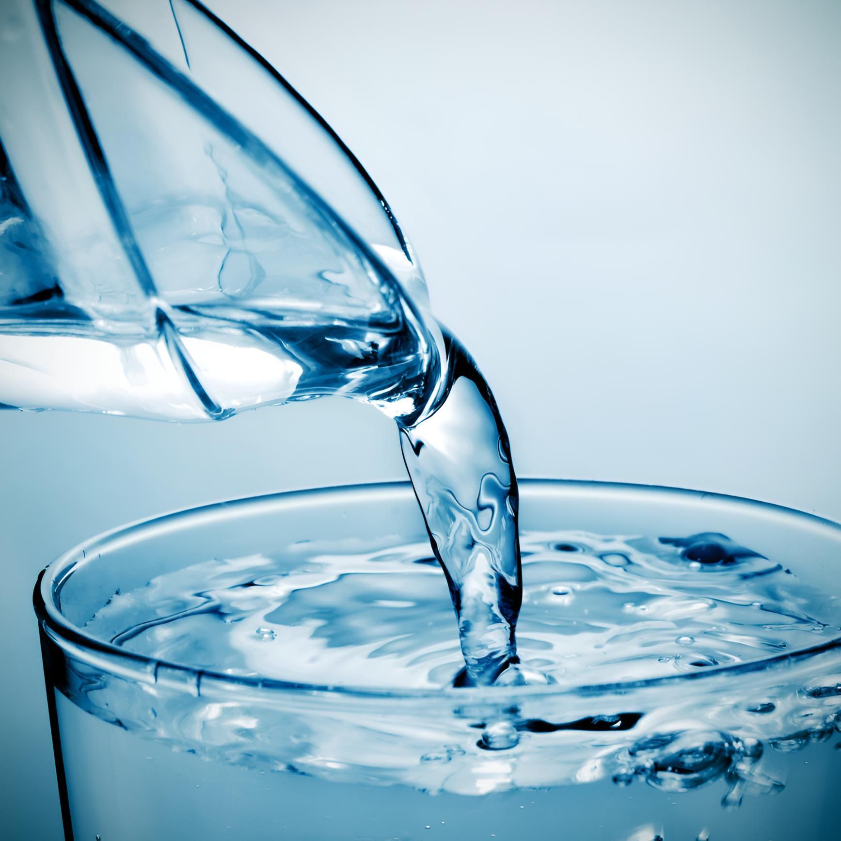 A Glass of Water is Being Poured Into a Glass — Porta-Vac in Bowen, QLD