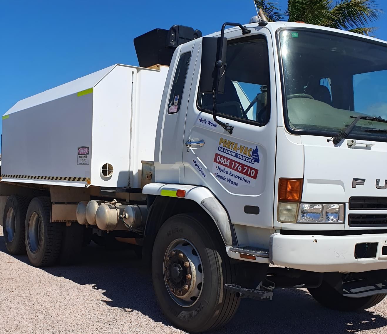 A White Truck Is Parked On A Gravel Road — Porta-Vac in Bowen, QLD