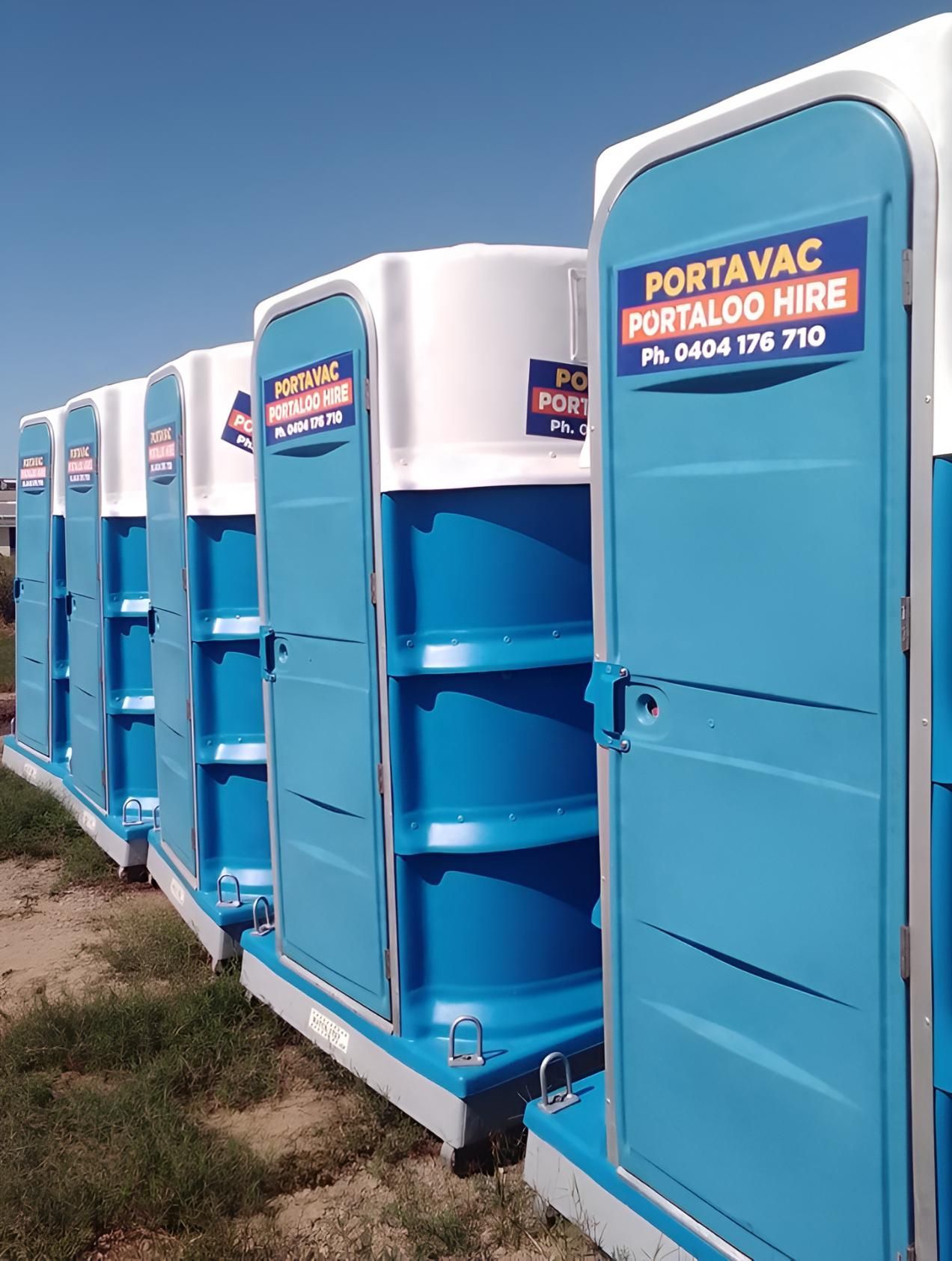 A Row of Blue and White Portable Toilets Are Lined Up in a Field — Porta-Vac in Moranbah, QLD
