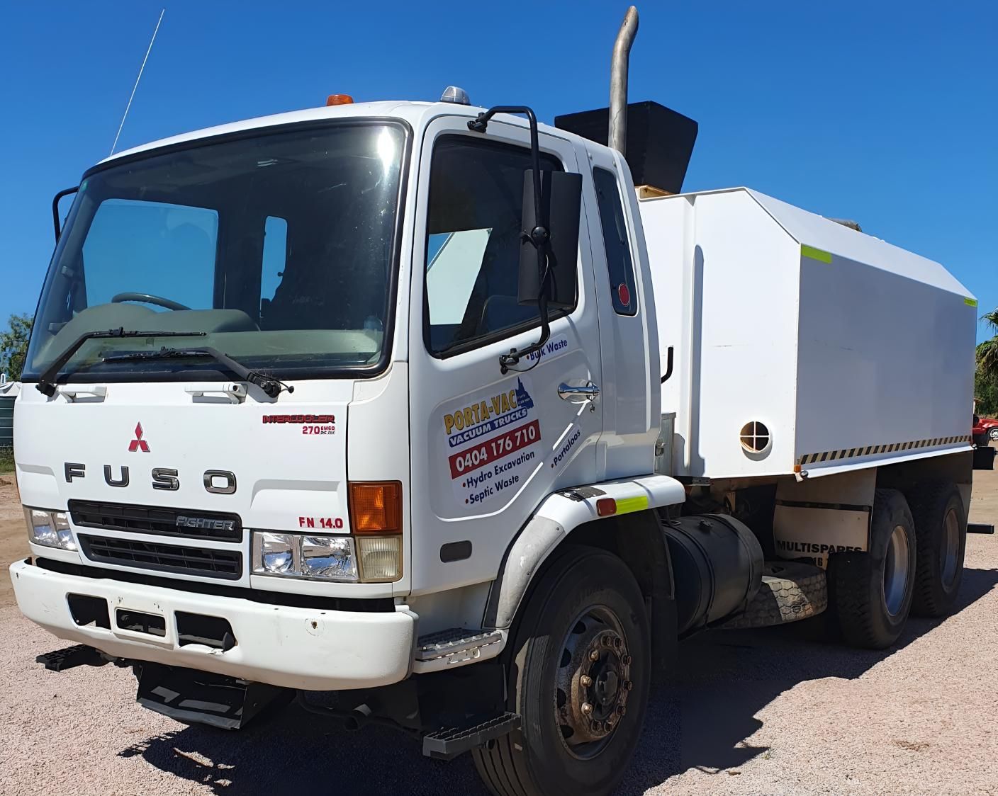A White Mitsubishi Truck is Parked on a Gravel Road — Porta-Vac in Cannonvale, QLD