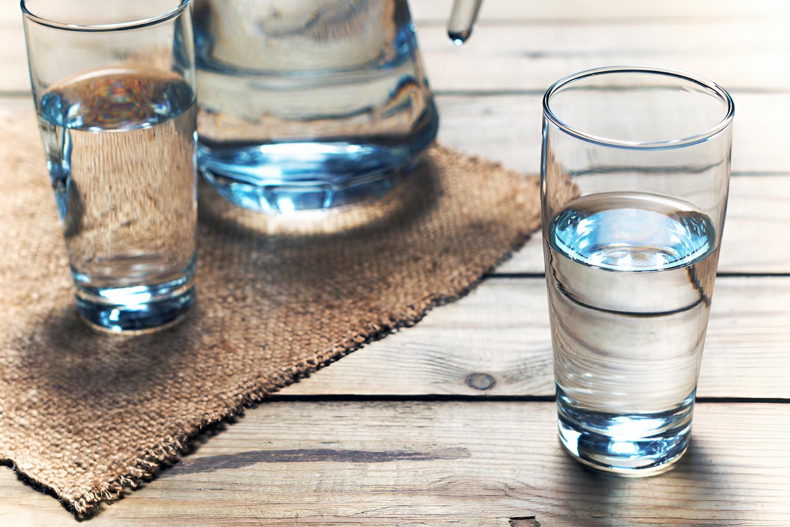 A Pitcher Of Water And Two Glasses Of Water On A Wooden Table — Porta-Vac in Bowen, QLD