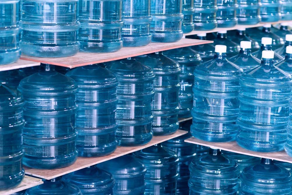 A Bunch Of Water Bottles Are Stacked On Top Of Each Other On Shelves — Porta-Vac in Cannonvale, QLD