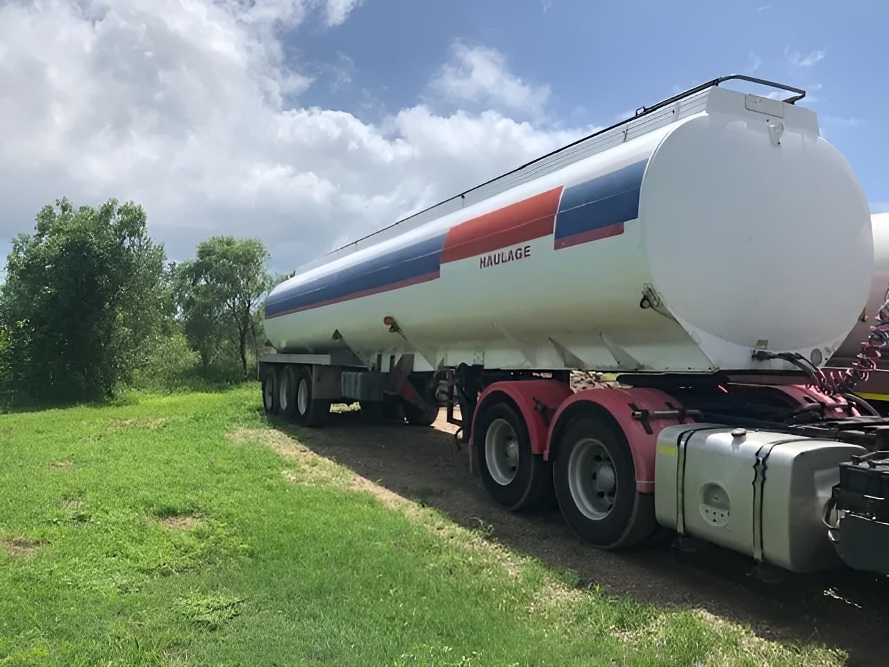 A Large Tanker Truck Is Parked In A Grassy Field — Porta-Vac in Bowen, QLD