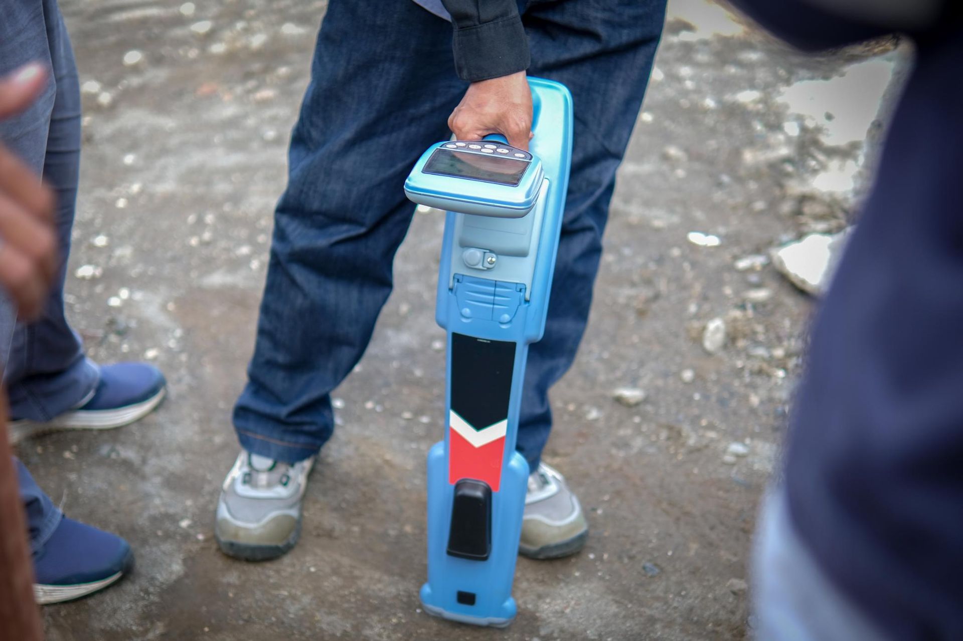 A Person is Holding a Blue Device With a Green Screen — Porta-Vac in Moranbah, QLD