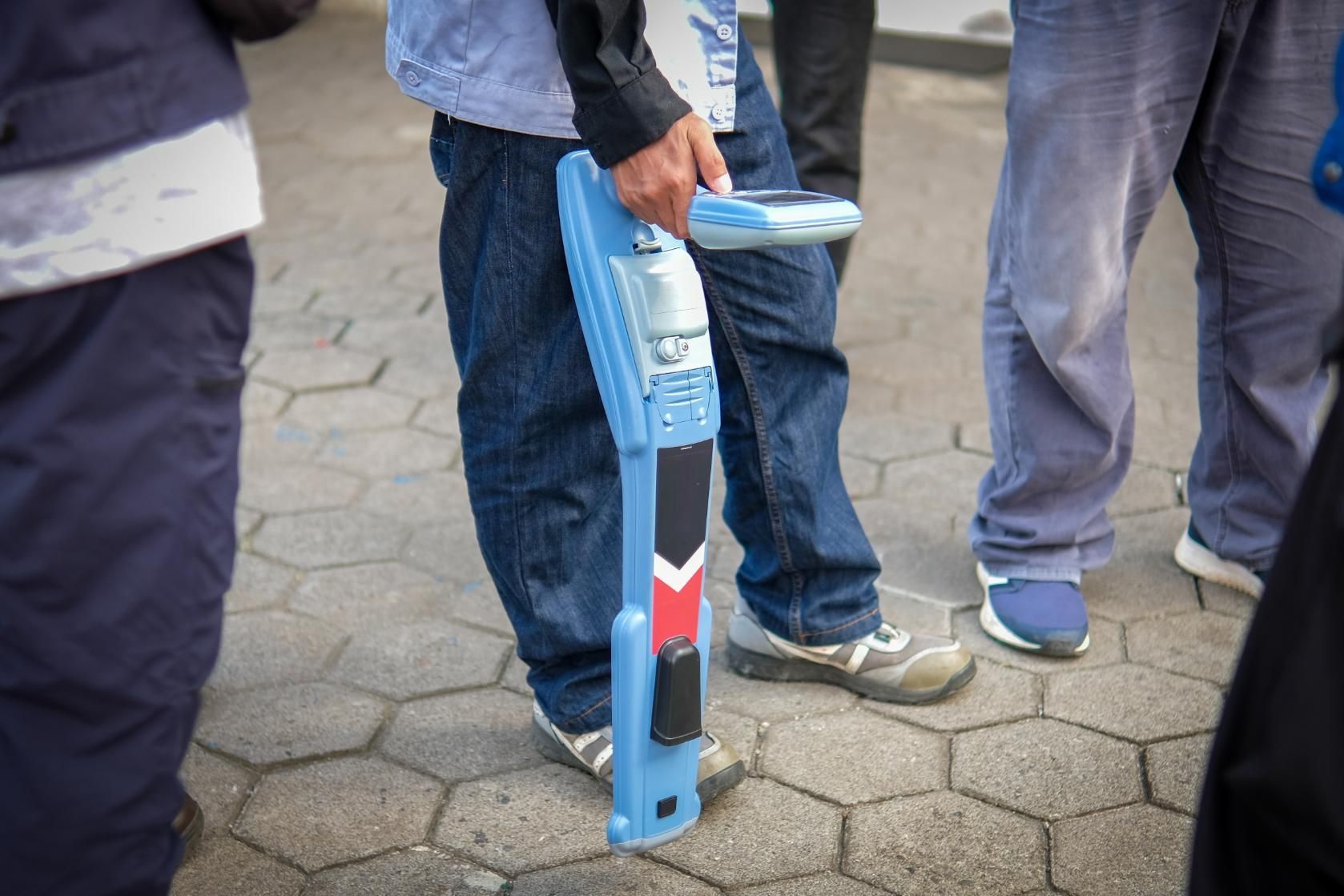 A Man is Holding a Blue Device — Porta-Vac in Airlie Beach, QLD