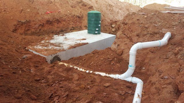 Construction site with a septic tank, pipes, and earth.