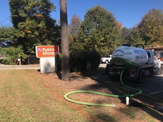 A septic tank truck servicing a storage facility's septic system next to a 