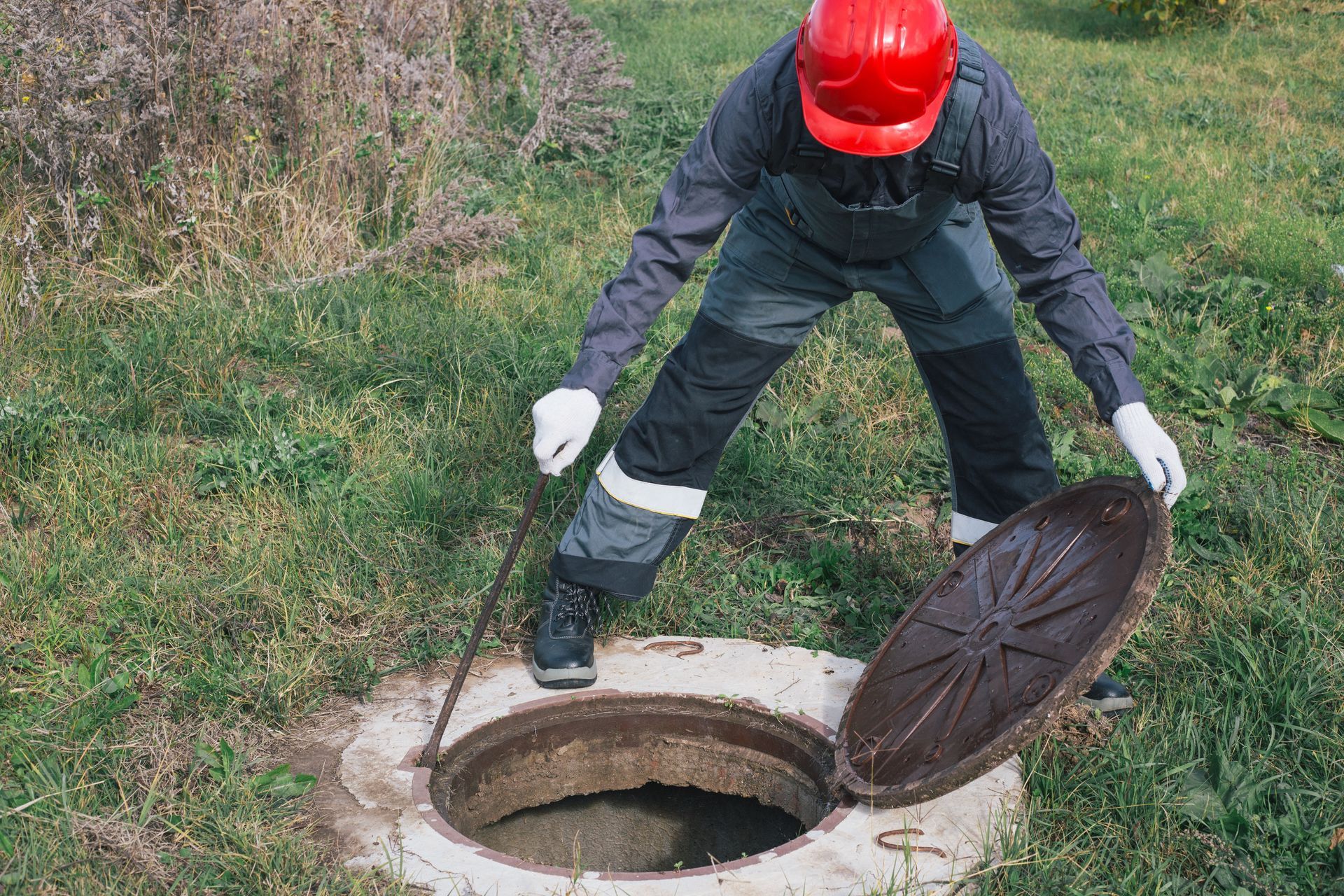 A man is inspecting a septic tank.