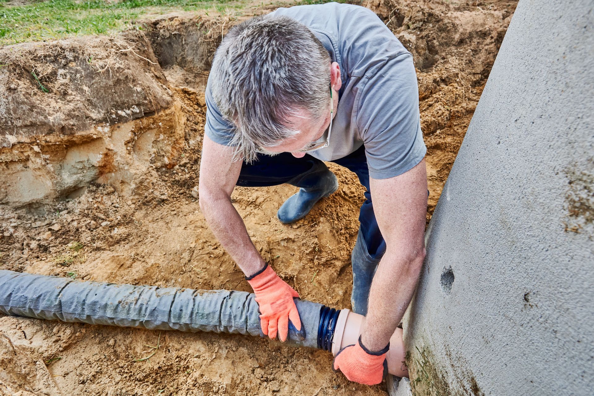A worker connecting a septic tank to an external disposal system. A worker connecting a septic tank to an external disposal system.