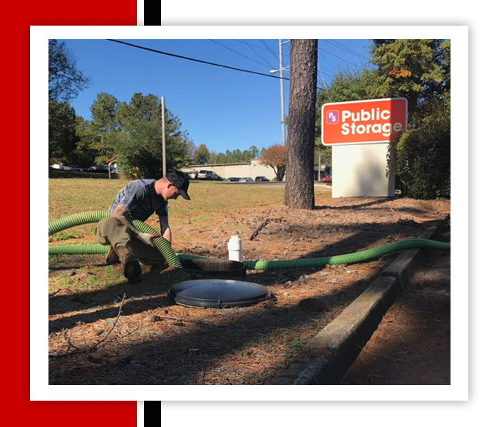 Man connecting hose to an access port near a Public Storage sign.